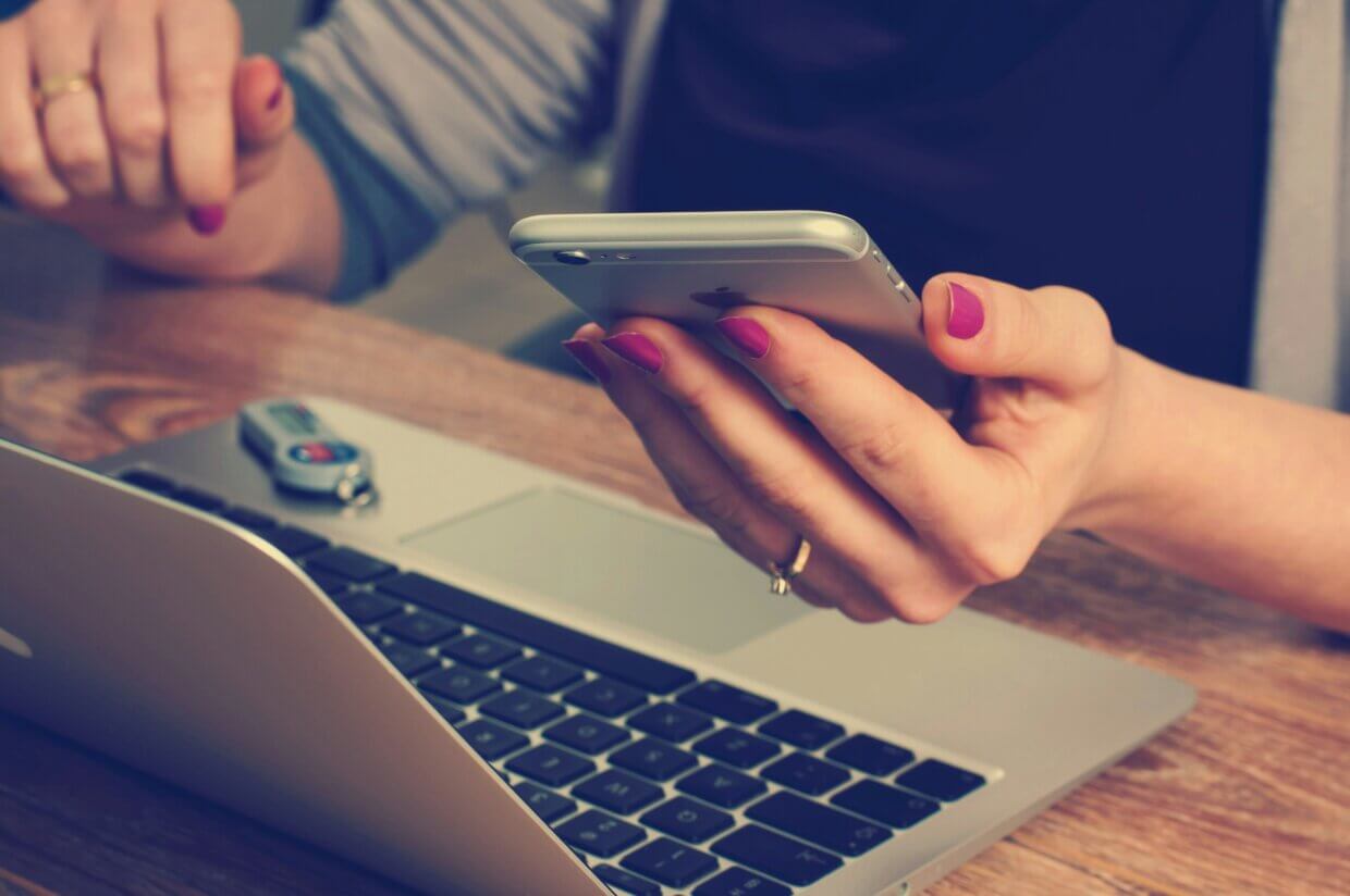 Bild von firmbee auf unsplash: Frau schaut auf ihr Handy
